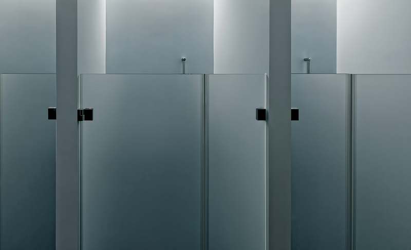 Close-up of a sleek black-framed shower panel with three spray modes and illuminated digital controls